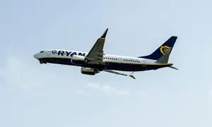 Samolot Ryanair wznoszący się na tle błękitnego nieba.