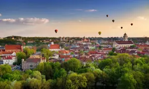 Widok na Wilno z lotu ptaka, z kilkoma balonami na gorące powietrze na niebie.