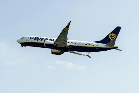 Samolot Ryanair wznoszący się na tle błękitnego nieba.