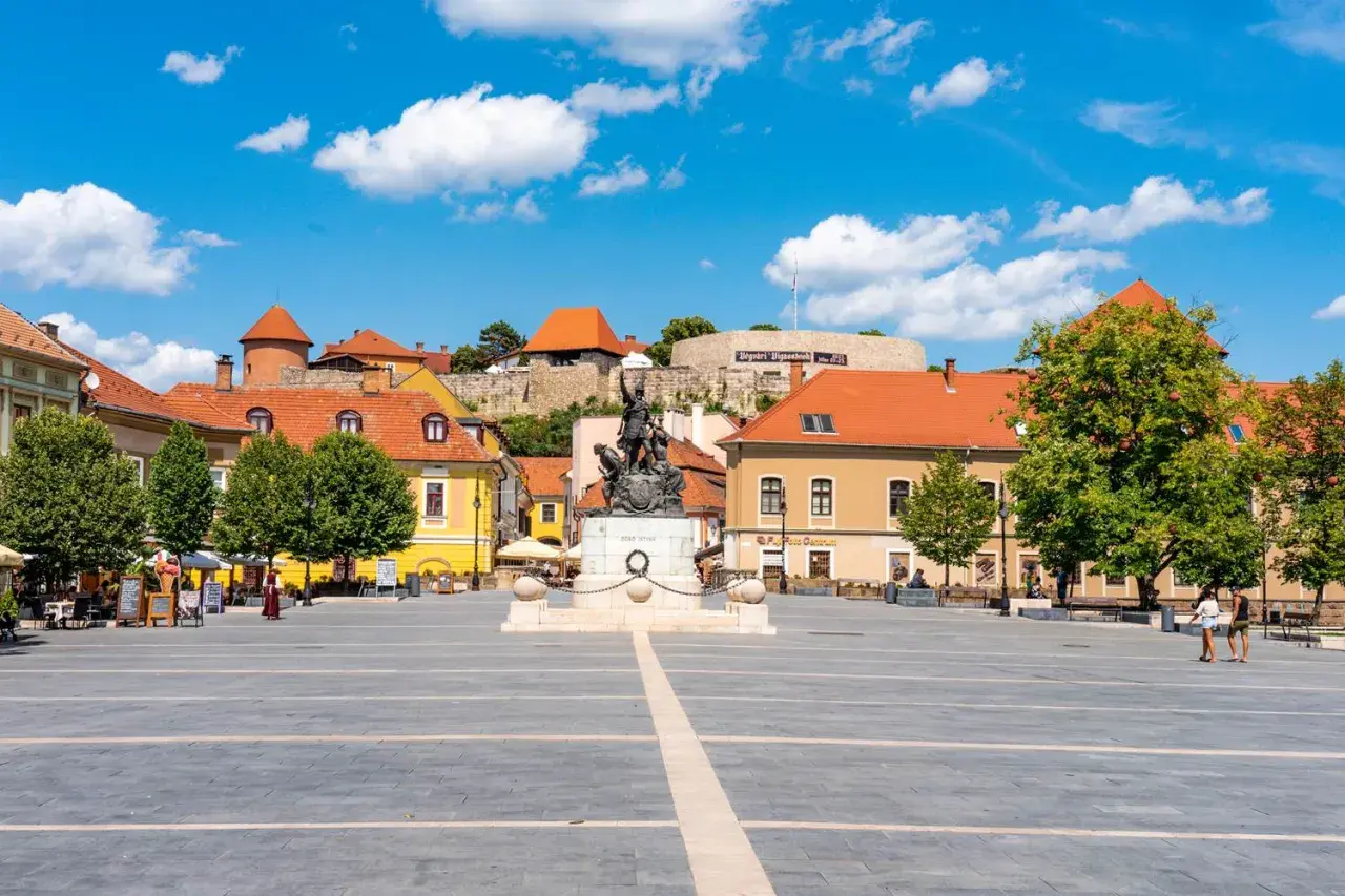 Plac z pomnikiem i budynkami w Egerze, Węgry.