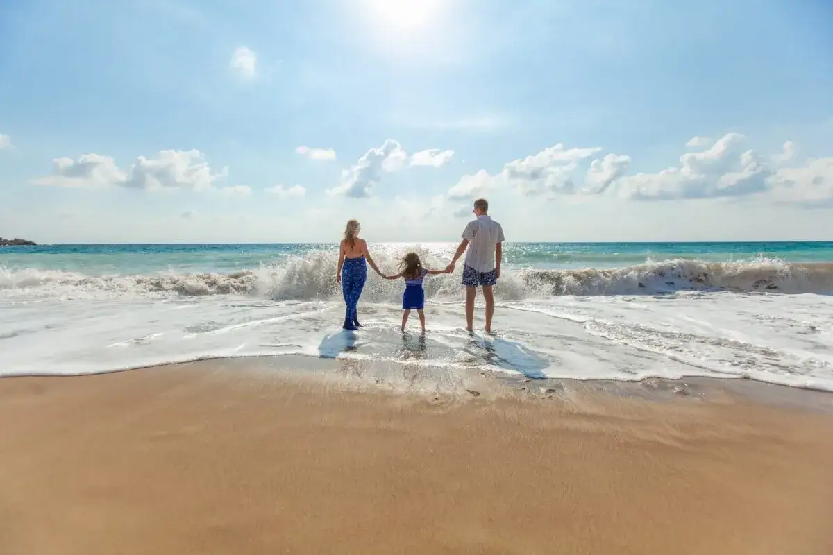 Rodzina na plaży, marząca o wakacjach. Jakie biuro podróży polecacie na takie wyjazdy?