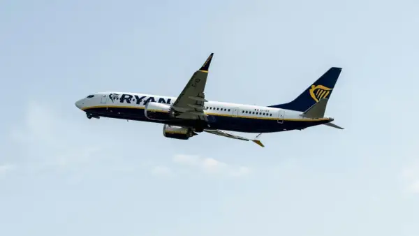 Samolot Ryanair wznoszący się na tle błękitnego nieba.