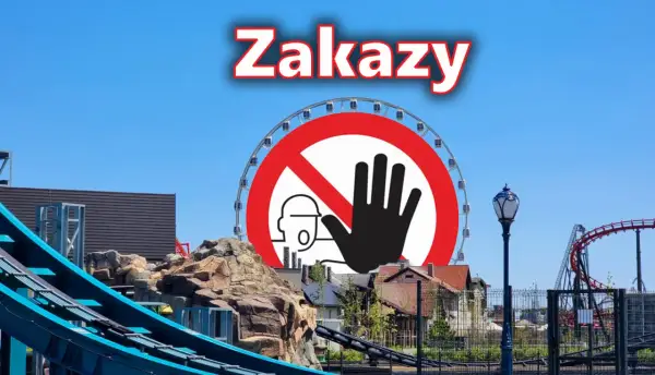 Znak zakazu na tle parku rozrywki Energylandia z diabelskim młynem i kolejką górską.